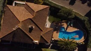 picture of tile roof in florida with pool and man on floater