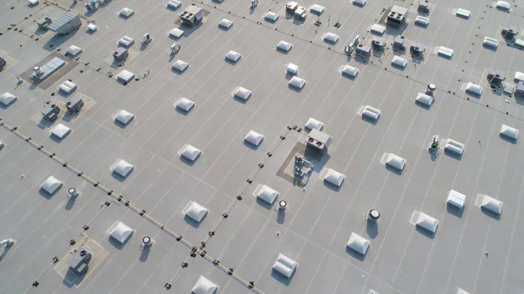 Aerial view of skylights and HVAC equipment on top of a commercial roof building