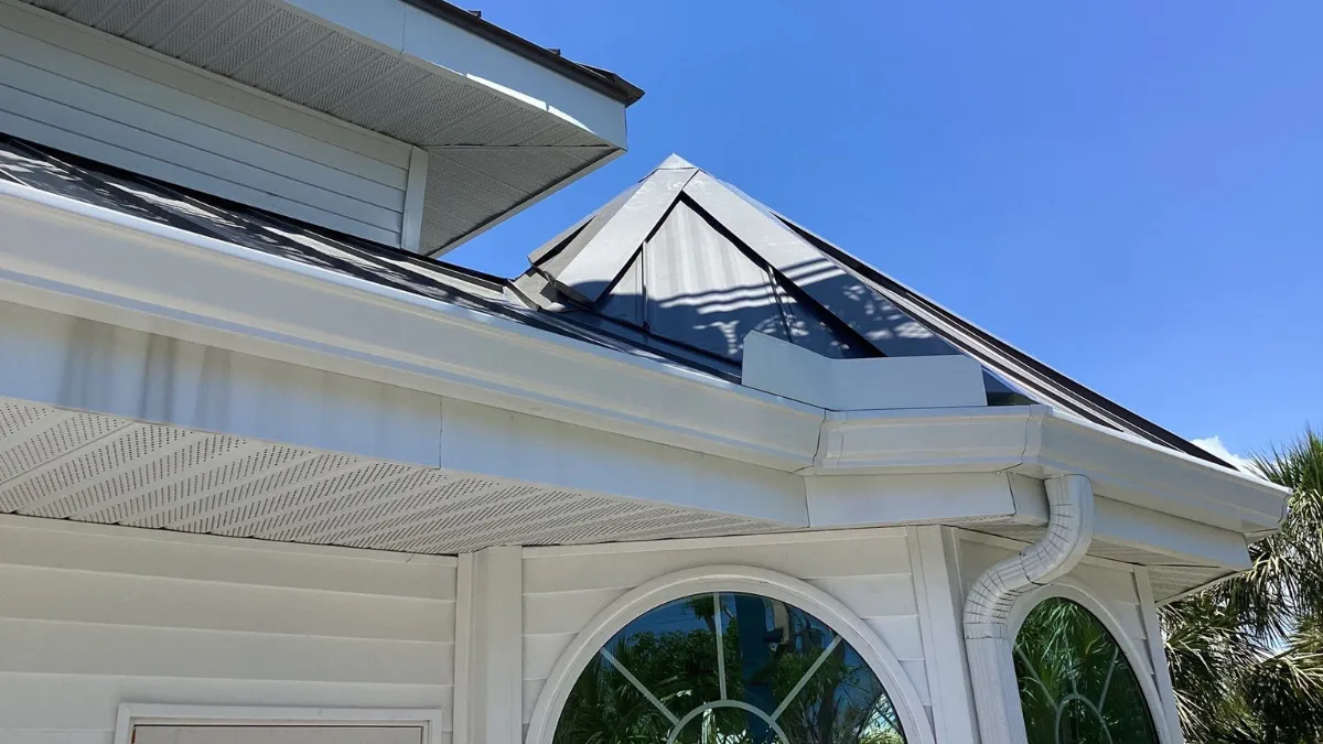 new white gutters on roof in florida, house with black roof and beautiful round windows