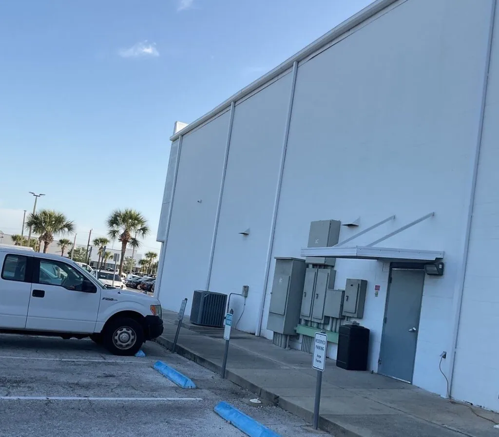 newly installed downspouts on an auto building in florida with palm trees in the background